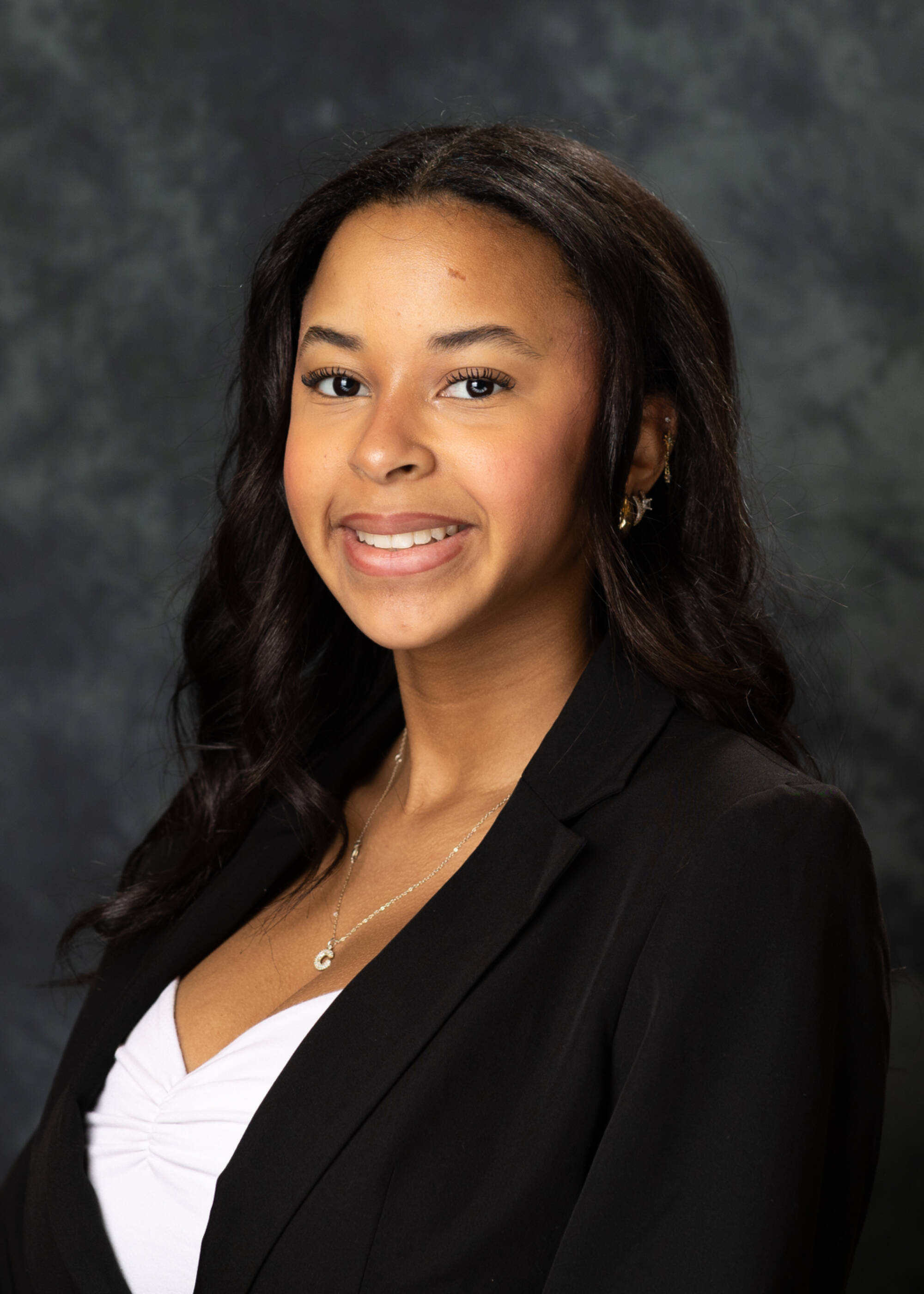 Carma Taverne smiling in a black blazer